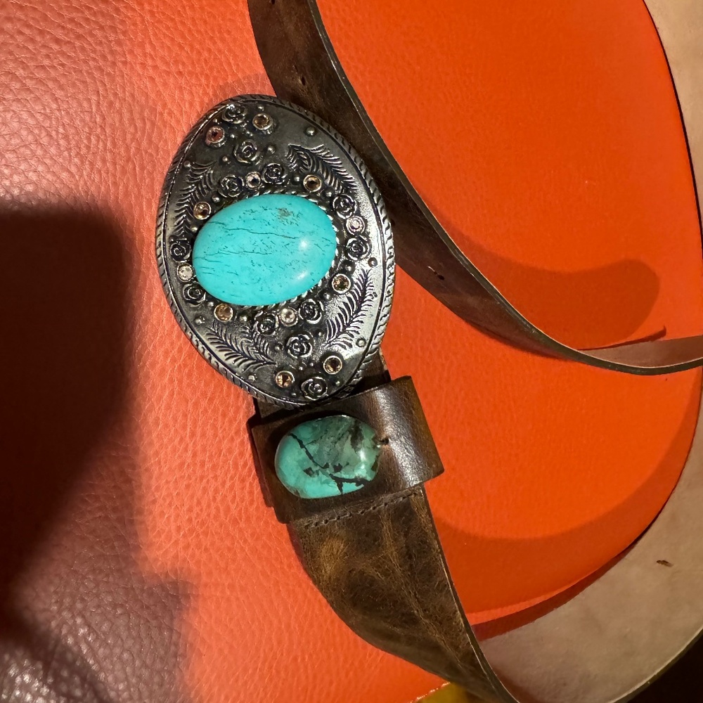 Pewter belt buckle with embedded turquoise.